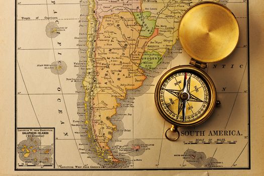 Antique brass compass over old XIX century map
