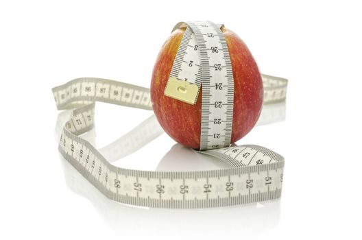 Apple wrapped with measuring tape. Isolated over white background. Dieting concept.