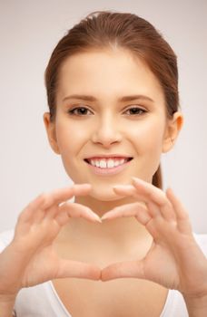 bright picture of happy woman making heart gesture