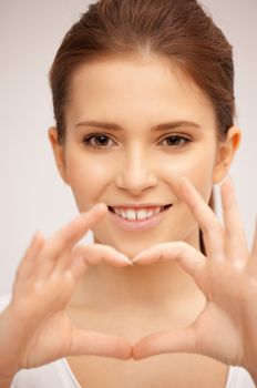 bright picture of happy woman making heart gesture