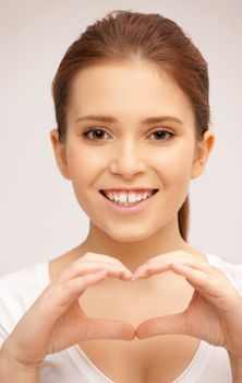 bright picture of happy woman making heart gesture