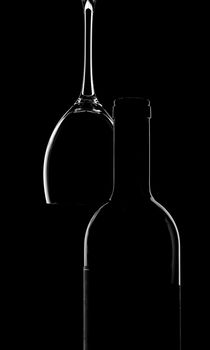 empty wine bottle and glass over black
