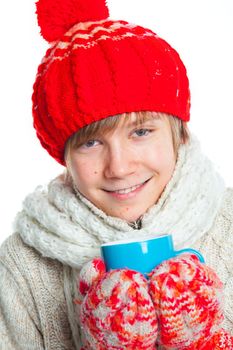 Portrait of young smiling cute teenager in a red hat and mittens with blue cup, isolated on white