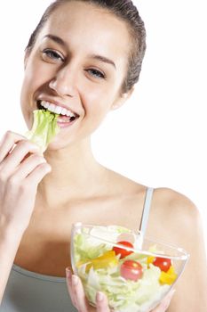 Woman eating salad. Portrait of beautiful smiling and happy woman enjoying a healthy salad and cherry tomatoes 