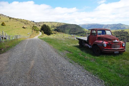 Red retro car at farm area, New Zealand