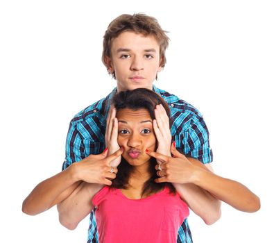 Smiling young man piddling his pretty girlfriend. Isolated on white background.