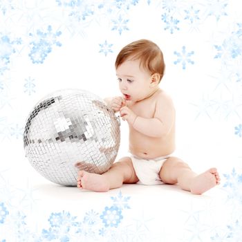 adorable baby boy with big glitterball and snowflakes