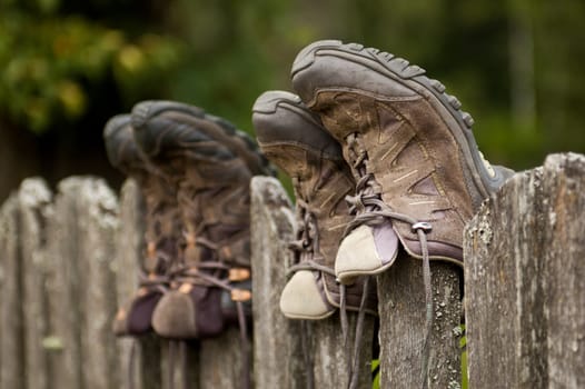 Worn hiking shoes on an old fence