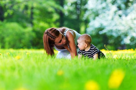 Happy mother and daughter on the green grass