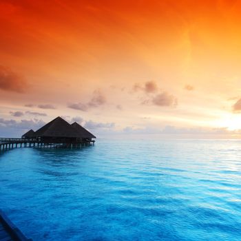 resort maldivian houses on sunrise