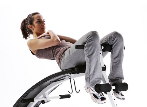 Woman using fitness machinery, white background