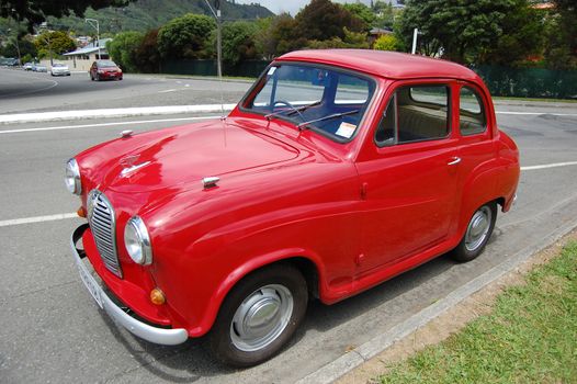 Red retro car at the roadside in Picton town, New Zealand