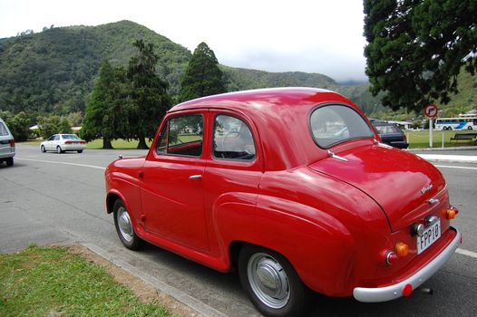 Red retro car at the roadside in Picton town, New Zealand