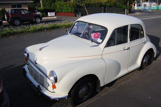 White retro car in the town street, New Zealand