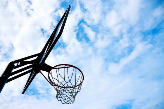 silhouette picture of basketball basket over blue sky