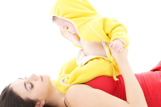 baby in yellow suit playing with mother