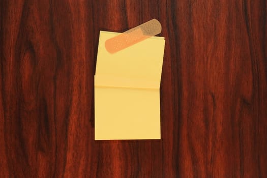 Yellow note paper with bandage on the door