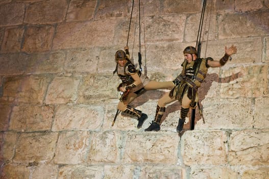 JERUSALEM - NOV 03 : An Israeli acrobats dressed as knight climbing on the old city walls in the annual medieval style knight festival held in the old city of Jerusalem on November 03 2011