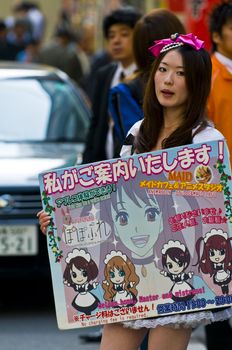 KYOTO , JAPAN - OCT 29 : Japanese girl dressed as a maid promoting "Maid cafe" in Tokyo Japan on October 29 2009 , In Maid cafes the waitresses dressed in maid costumes and act as servants , these cafes are very popular in Japan 