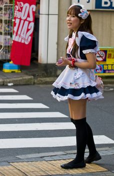 KYOTO , JAPAN - OCT 29 : Japanese girl dressed as a maid promoting "Maid cafe" in Tokyo Japan on October 29 2009 , In Maid cafes the waitresses dressed in maid costumes and act as servants , these cafes are very popular in Japan 