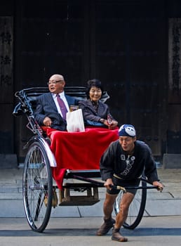 TOKYO - OCT 29 : Japanese couple on a trditional rickshaw being pulled on October 29 2009 in Tokyo , Japan