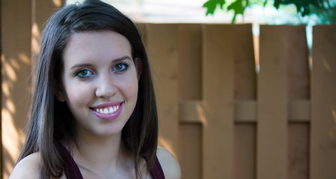 Headshot of a pretty teen girl outside.