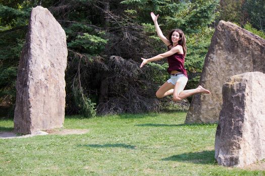 Pretty girl jumps in the park - copyspace