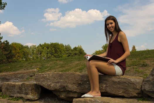 Pretty girl reading in the park - copyspace