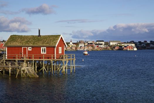 Typical red rorbu hut with sod roof in town of Reine on Lofoten islands in Norway