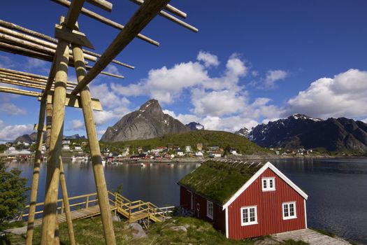 Traditional red rorbu hut with sod roof in town of Reine on Lofoten islands in Norway