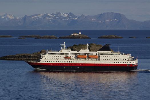 Large passenger ship cruising along norwegian coast with tiny rocky islets near Lofoten islands