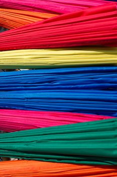 Background from closed multicolored umbrellas made in Bo Sang village, Chiang Mai province, Thailand
