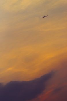 Airplane flying to the sunset sky