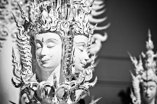 Statue of mythological head in Wat Rong Khun. Wat Rong Khun is a contemporary unconventional Buddhist temple in Chiang Rai, Chiangmai province, Thailand. It is designed in white color.