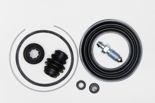 Caliper repair kit, retaining ring, oil seal, union, rubber gaskets. Set of spare parts for car brake repair. Details on white background, copy space available. UHD 4K.