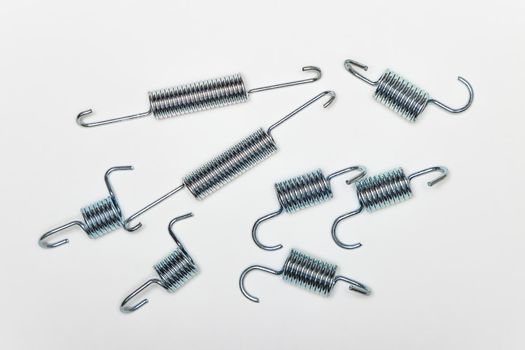 Repair kit for brakes, many metal springs of various lengths. Set of spare parts for car brake repair. Details on white background, copy space available. UHD 4K.