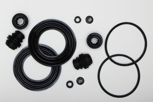 Caliper repair kit, rubber gaskets, oil seals, seals. Set of spare parts for car brake repair. Details on white background, copy space available. UHD 4K.