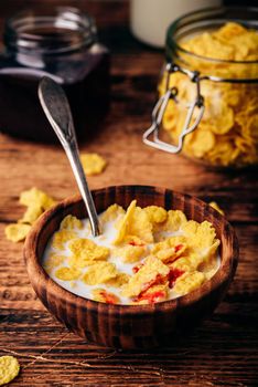 Breakfast with corn flakes, milk and berry syrup