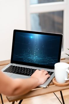 Hand Resting On Laptop Top Of Table Beside Cup Working From Home.