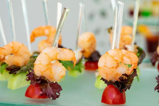 Small sandwiches on a stick. Snack with shrimp and salad