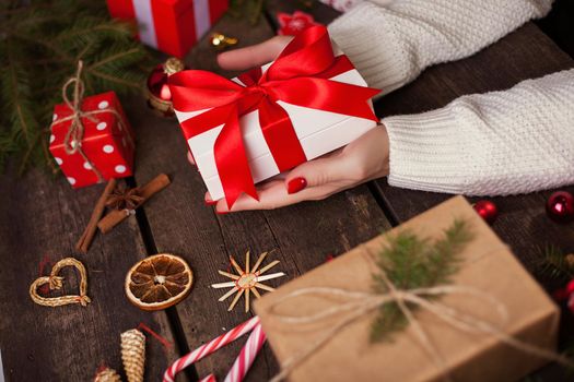Gift box in wrapping paper with satin ribbon. Merry Christmas holiday concept.