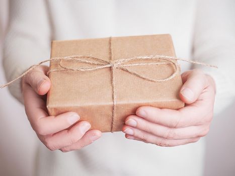 Gift box in wrapping paper with satin ribbon. Merry Christmas holiday concept.