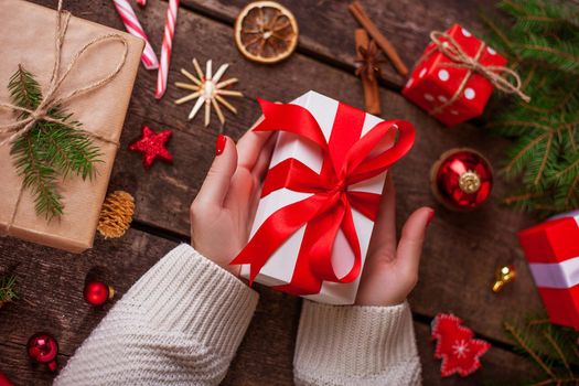 Gift box in wrapping paper with satin ribbon. Merry Christmas holiday concept.