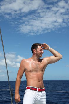 Man enjoying summer time holiday on sailing boat.