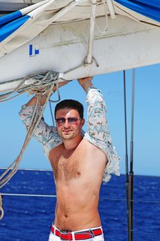 Man enjoying summer time holiday on sailing boat.