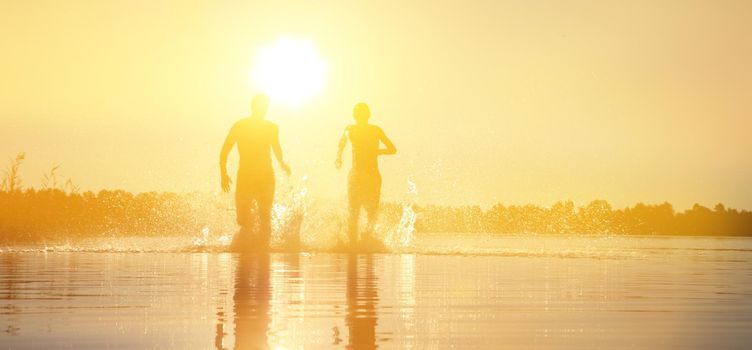 Group of young people playing games on sandy beach on a summer day.