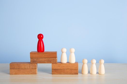 Career growth, development. Leadership, goal achievement. Wooden people figures on top of wooden blocks