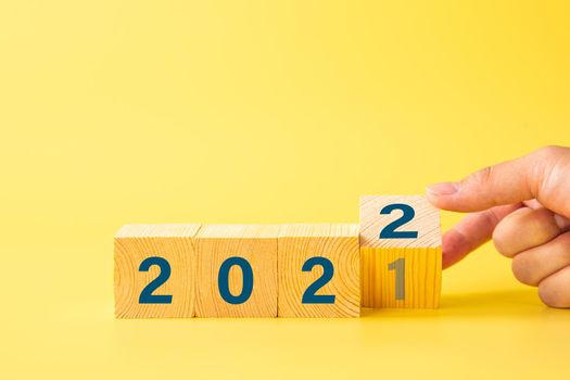 Businessman flipping 2021 to 2022 year for start new year business plan. Business Concept