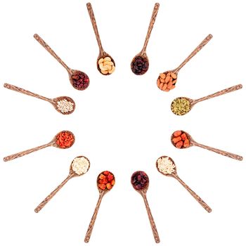 Top view group of various types of dried fruits on a wooden spoon isolated on white background.