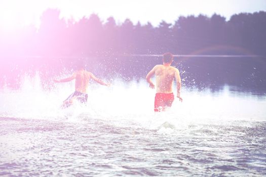 Group of young people playing games on sandy beach on a summer day.